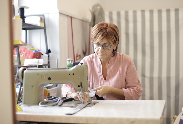 žena šije na šicím stroji